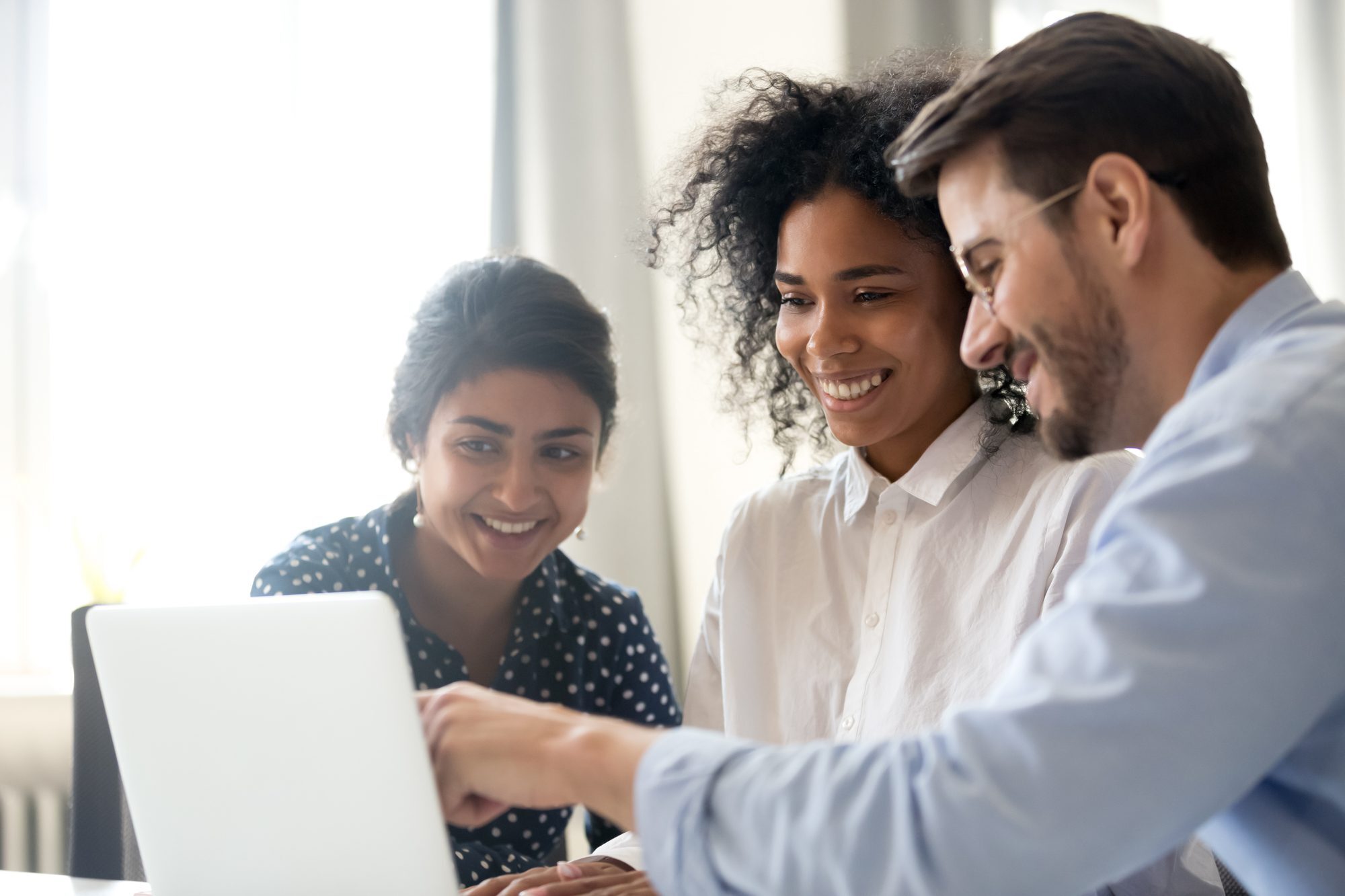 Smiling multi-ethnic coworkers work together